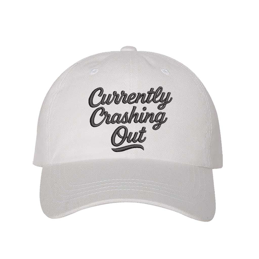 White with black thread Currently Crashing Out embroidered baseball hat. A statement baseball hat for women who love humor, comfort, and effortless everyday outfits. - DSY Lifestyle