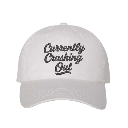 White with black thread Currently Crashing Out embroidered baseball hat. A statement baseball hat for women who love humor, comfort, and effortless everyday outfits. - DSY Lifestyle