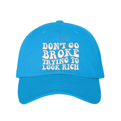 Aqua Don’t Go Broke Trying to Look Rich Embroidered Baseball Hat in soft cotton with curved brim and hook and loop closure. DSY Lifestyle.