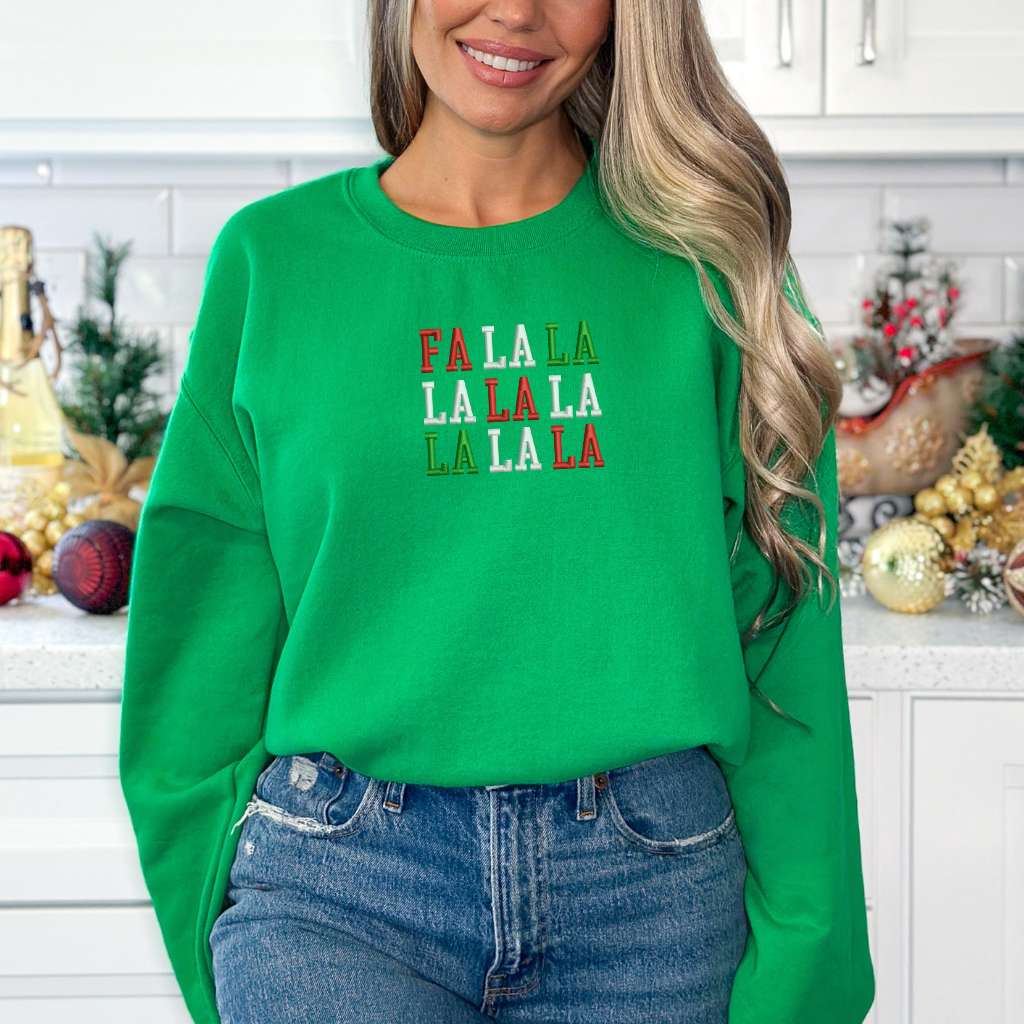 Female wearing a kelly green sweatshirt embroidered with Fa la la in Christmas Colors - DSY Lifestyle