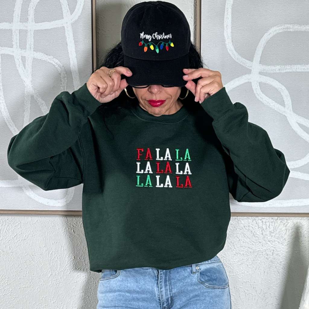 Female wearing a Forest Green sweatshirt embroidered with Fa la la in Christmas Colors - DSY Lifestyle