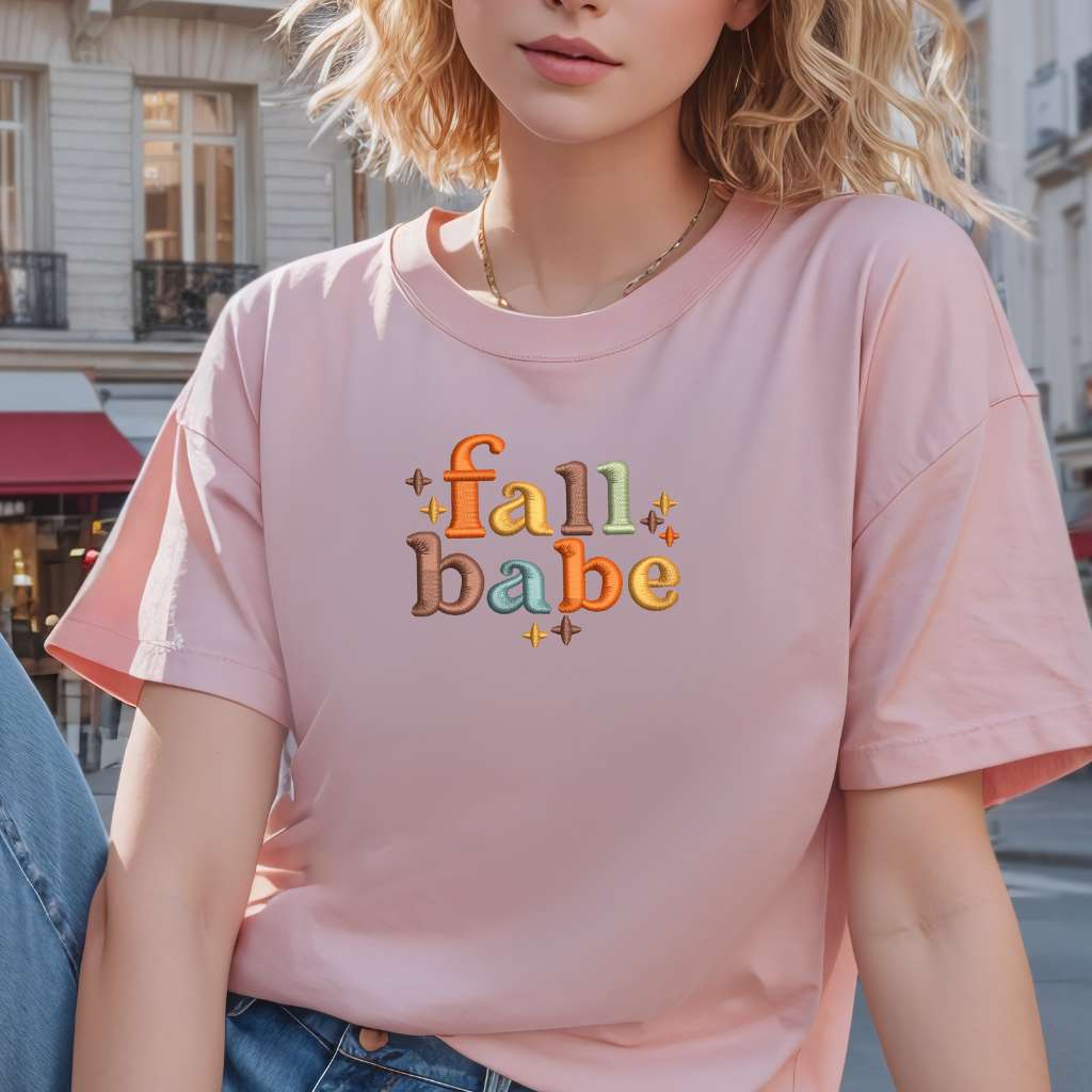 Female wearing a pink t-shirt embroidered with Fall Babe - DSY Lifestyle
