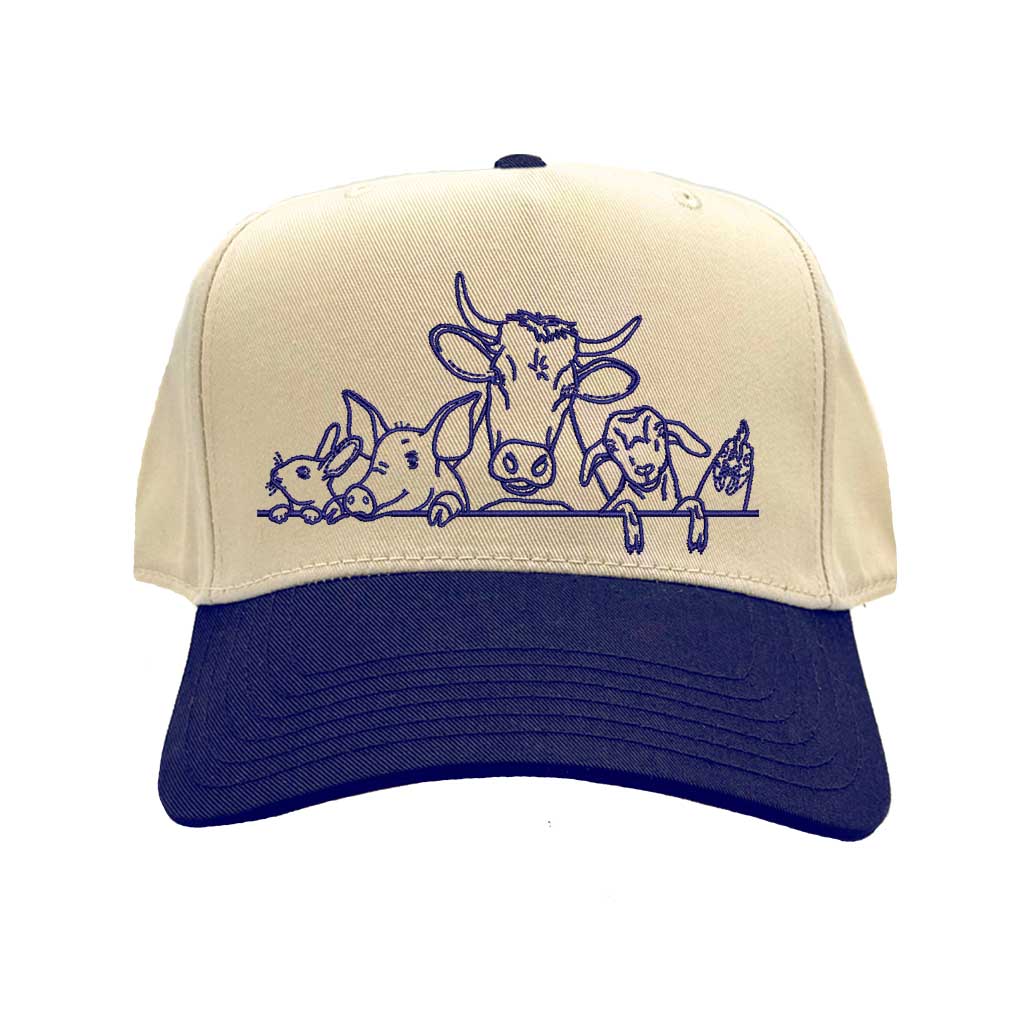 Natural Navy Blue DSY Lifestyle two-tone baseball hat with a natural crown and  contrasting bill, featuring an embroidered graphic of a cow, pig, and rooster family. - DSY Lifestyle