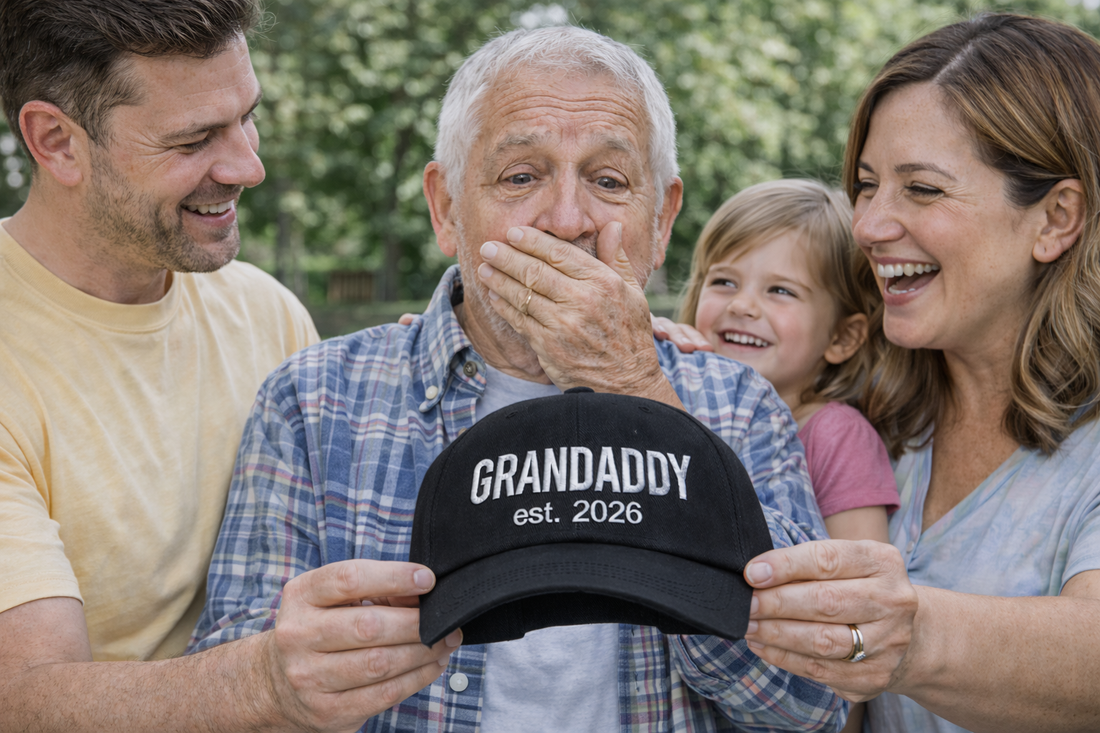 Family of three presenting handsome man with a Black GrandDaddy Est. 2026 Baseball Hat featuring bold white embroidery on a classic dad cap; the perfect 2026 baby announcement gift for new grandfathers by DSY Lifestyle.
