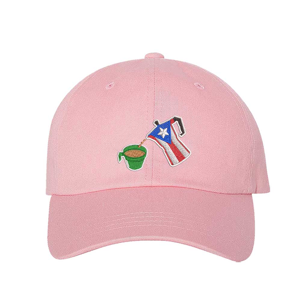 A pink embroidered hat featuring a detailed design of a greca (stovetop coffee maker) pouring coffee into a nostalgic green butter cup, symbolizing Puerto Rican coffee culture. The greca has the Puerto Rican flag inside it, representing heritage and tradition - DSY Lifestyle