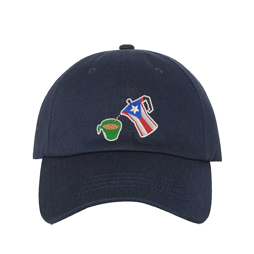 A navy embroidered hat featuring a detailed design of a greca (stovetop coffee maker) pouring coffee into a nostalgic green butter cup, symbolizing Puerto Rican coffee culture. The greca has the Puerto Rican flag inside it, representing heritage and tradition. DSY Lifestyle