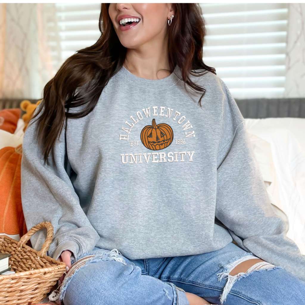 Female wearing a Heather Gray sweatshirt embroidered with Halloweentown University Est. 1998 and a pumpkin - DSY Lifestyle