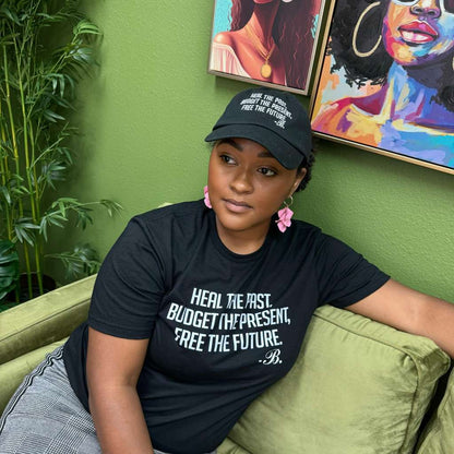 Front view of the &quot;Heal the Past, Budget the Present, Free the Future&quot; hat – A motivational financial coach wears the hat, showcasing the embroidered mantra clearly on the front.