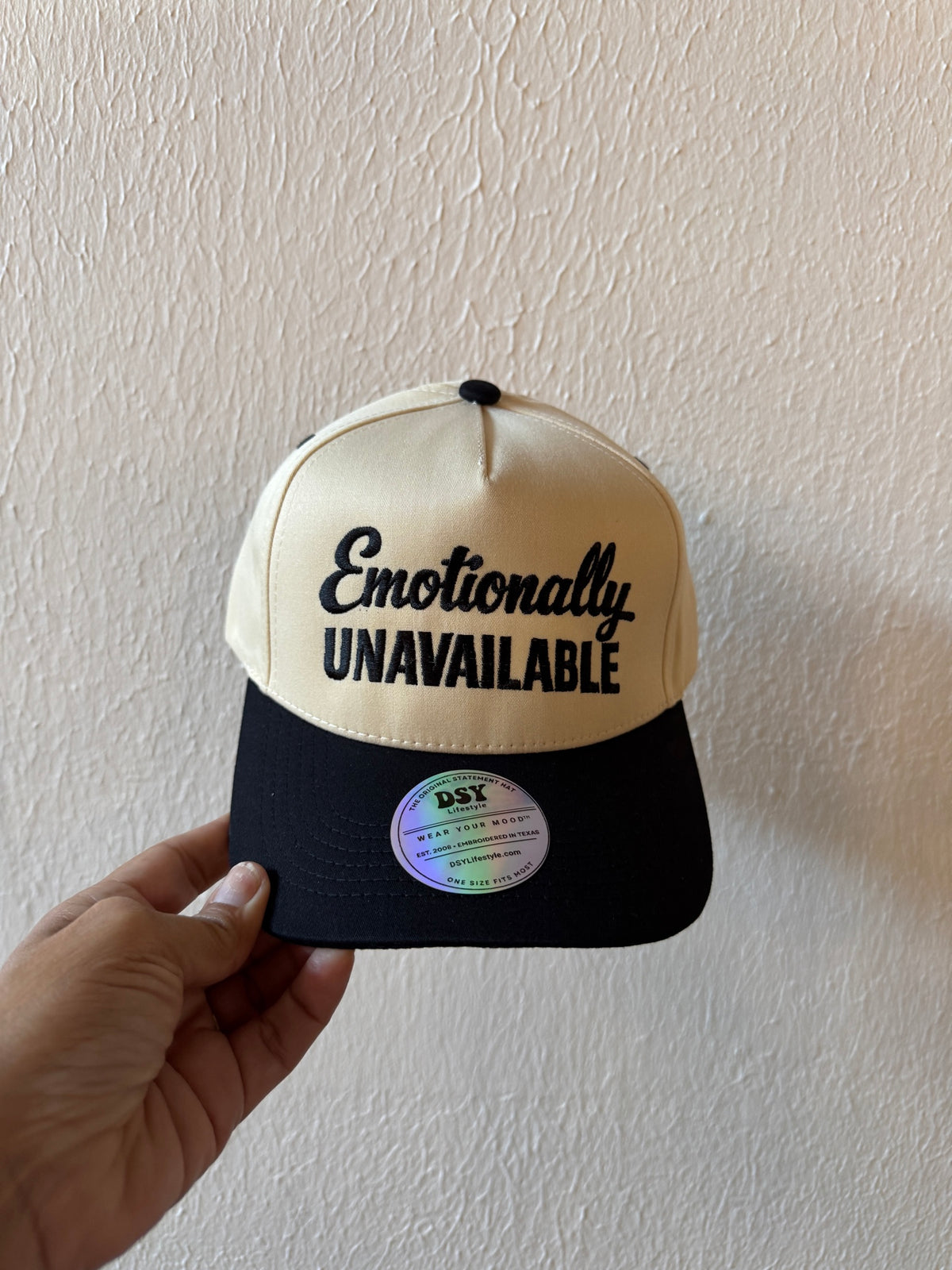 Emotionally Unavailable embroidered two-tone trucker hat on a white background
