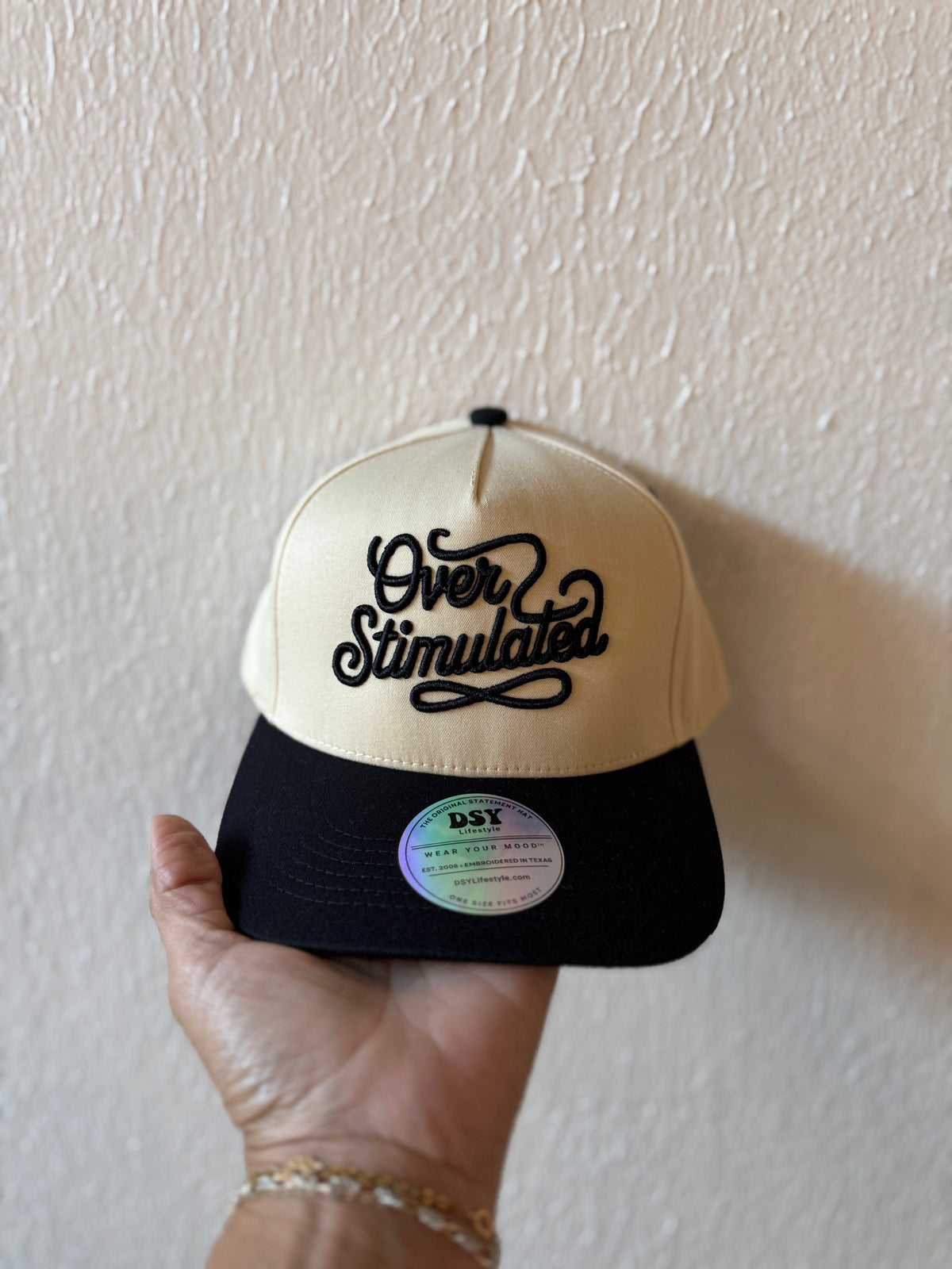 Over Stimulated embroidered two-tone trucker hat on a white background