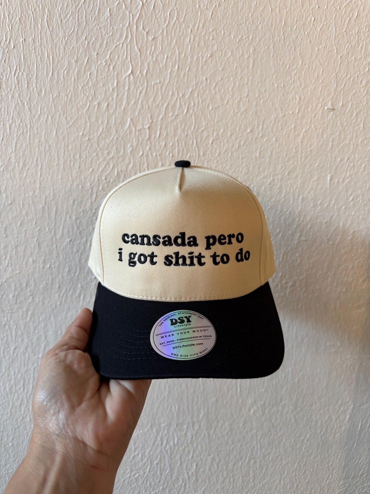 Cansada Pero I Got Shit to Do embroidered two-tone trucker hat on a white background