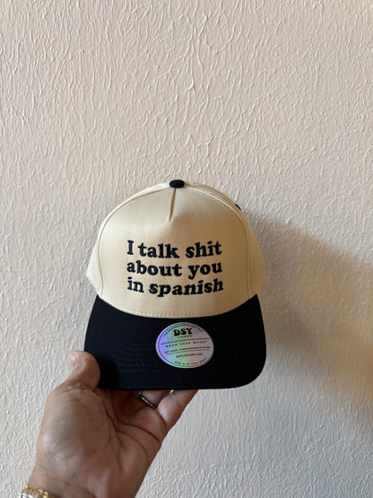 I Talk Shit About You in Spanish embroidered two-tone trucker hat on a white background