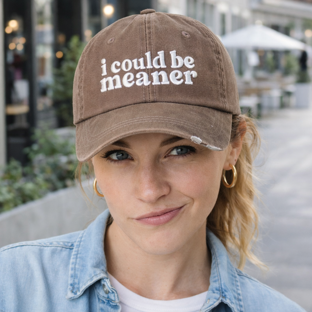 Female in urban setting with a sarcastic look wearing a Chocolate Brown DSY Lifestyle washed cotton baseball hat featuring the phrase I Could Be Meaner in bold, professional embroidery. - DSY Lifestyle
