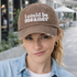 Female in urban setting with a sarcastic look wearing a Chocolate Brown DSY Lifestyle washed cotton baseball hat featuring the phrase I Could Be Meaner in bold, professional embroidery. - DSY Lifestyle