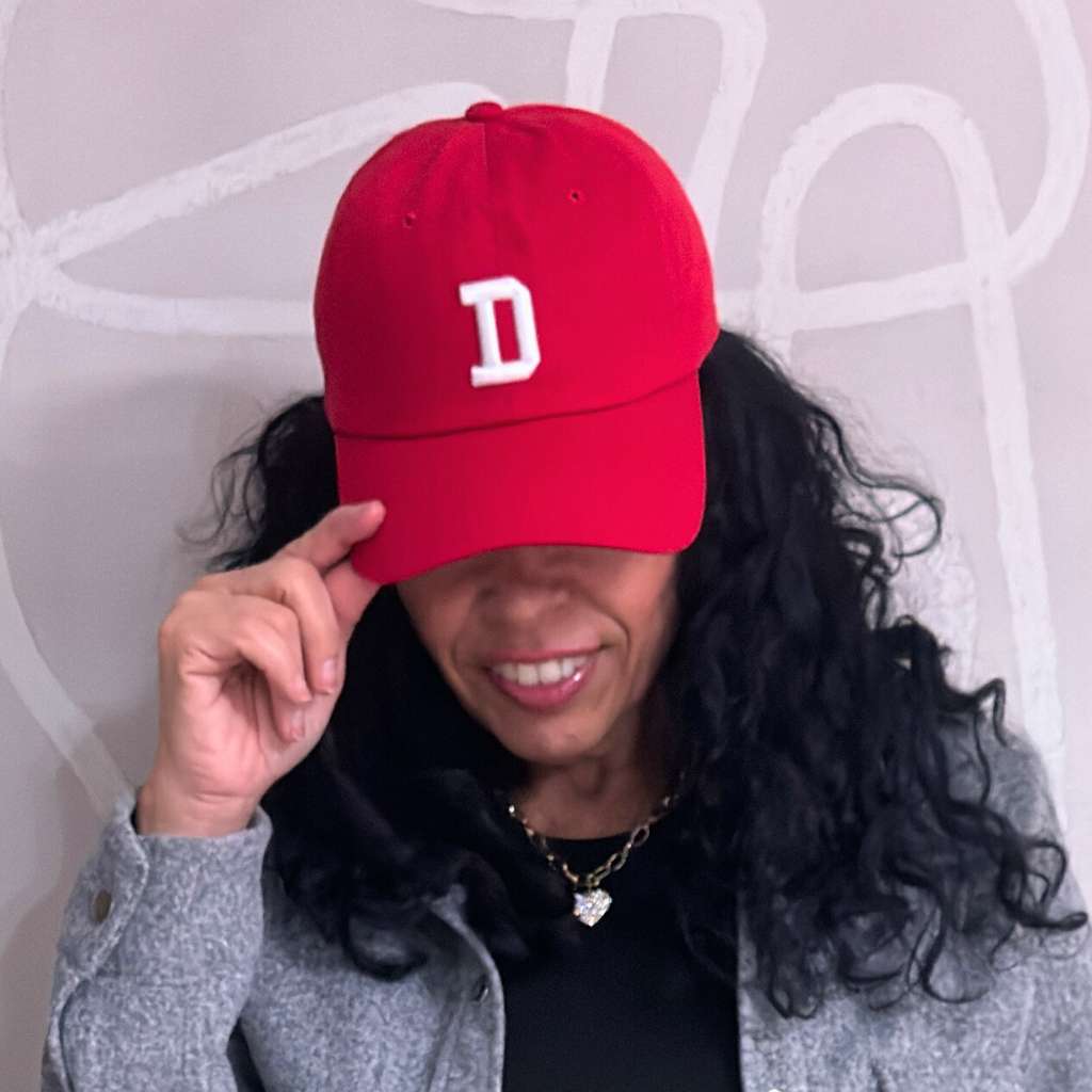 Woman wearing a red baseball hat embroidered with a custom 3d puff letter D