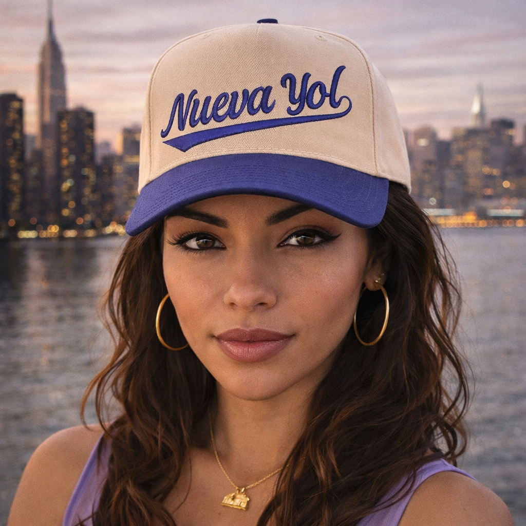 Woman wearing a embroidered baseball cap with Nueva York text against a city skyline backdrop