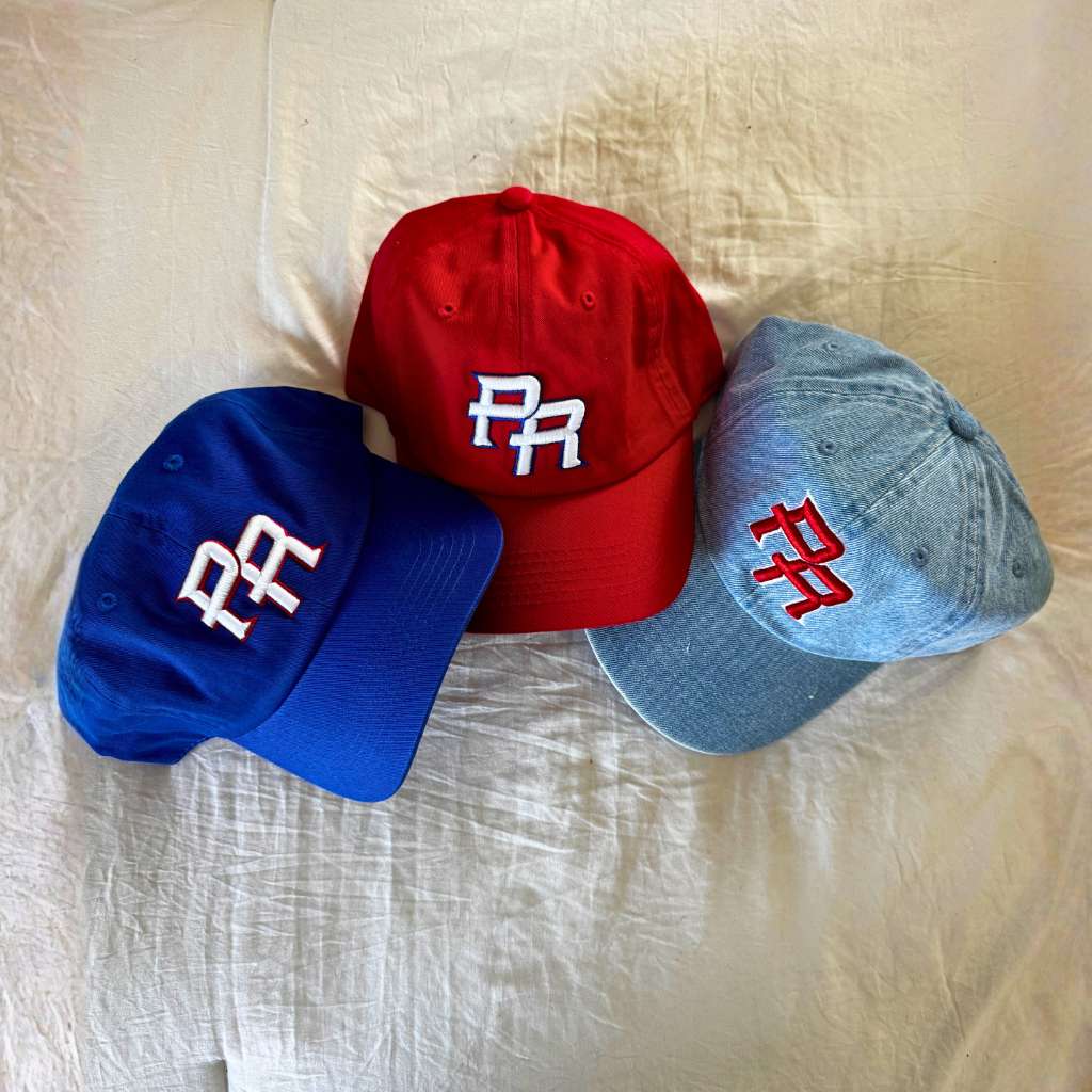 Three baseball caps in red, blue, and gray embroidered with  Puerto Rico  initials in 3D and Puerto Rico flag on the side by DSY Lifestyle