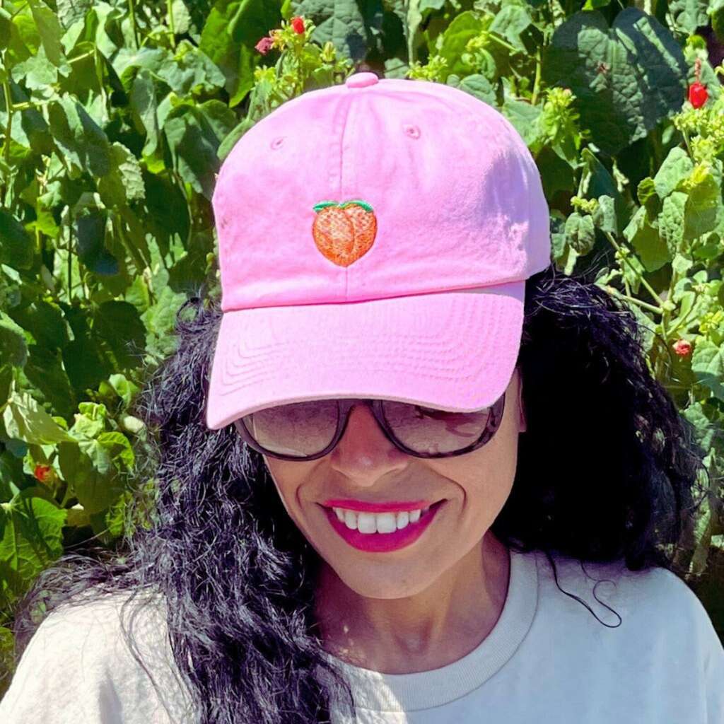 Female wearing a Pink Baseball Hat embroidered with a peach emoji- DSY Lifestyle