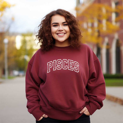 Woman wearing a embroidered maroon sweatshirt with PISCES text outdoors - DSY Lifestyle