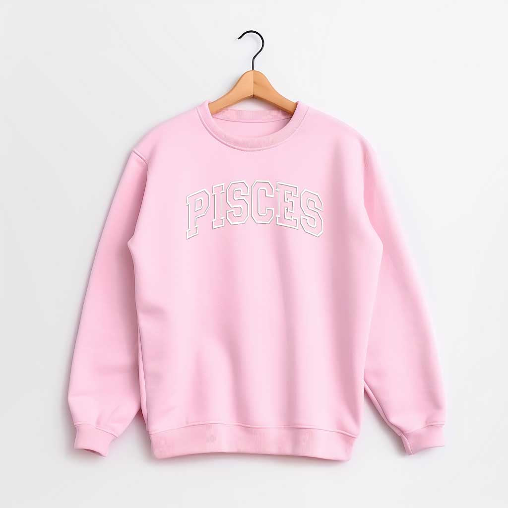 Pink sweatshirt with embroidered PISCES text on a hanger against a white background DSY Lifestyle