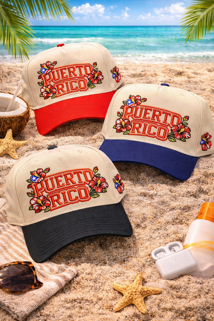 Flat lay laying on bed of sand Natural Black, Natural Red, and Natural Navy Blue Puerto Rico in Bloom embroidered baseball hats. A two-tone statement hat for women who love culture, effortless outfits, and bold style. - DSY Lifestyle