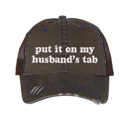 Brown front profile view of a DSY Lifestyle distressed trucker hat featuring the words Put It On My Husband&