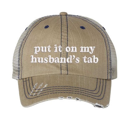 Khaki front profile view of a DSY Lifestyle distressed trucker hat featuring the words Put It On My Husband&
