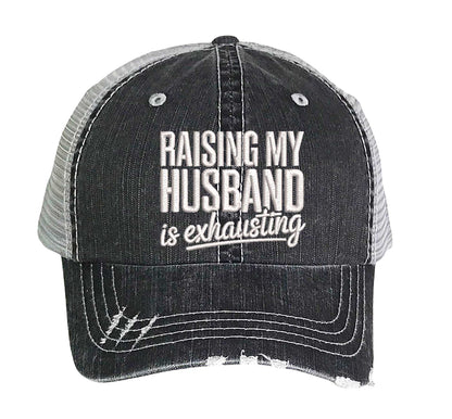 Black DSY Lifestyle distressed trucker hat featuring the phrase Raising My Husband Is Exhausting in bold, professional embroidery. - DSY Lifestyle