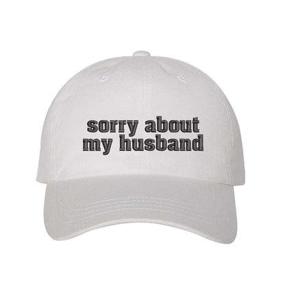 White Sorry About My Husband Embroidered Baseball Hat in classic cotton dad cap style with curved brim and hook and loop closure. DSY Lifestyle.