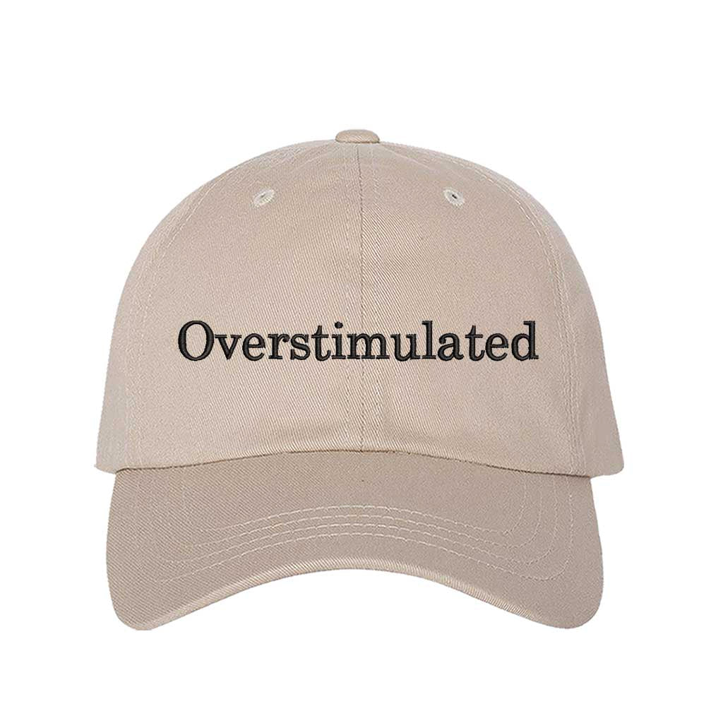 Stone DSY Lifestyle soft cotton baseball hat with the word Overstimulated embroidered in clean, minimalist lowercase lettering across the front. - DSY Lifestyle