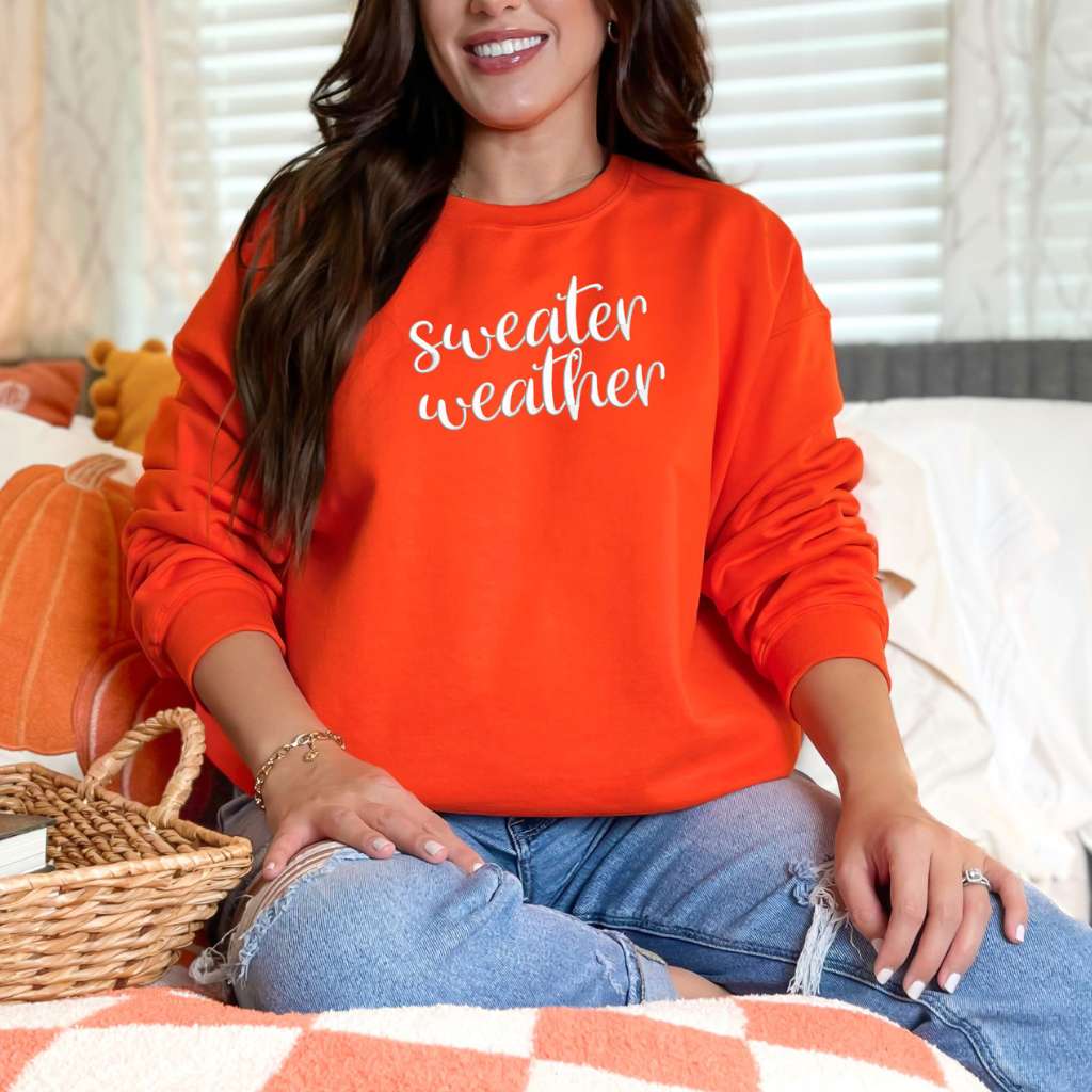Female wearing a Orange Sweatshirt with sweater weather embroidered in the front - DSY Lifestyle