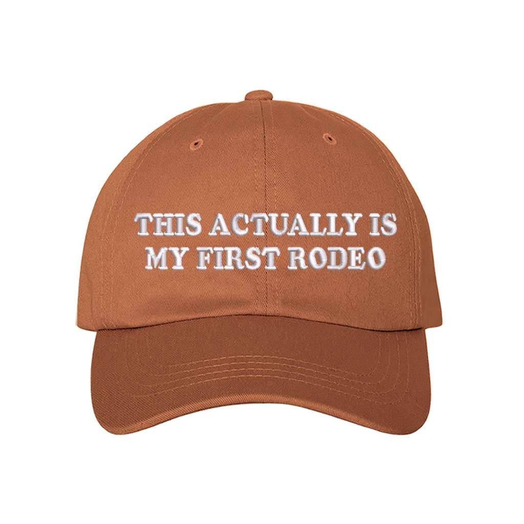 Burnt Orange baseball hat with the phrase this actually is my first rodeo embroidered on it- DSY Lifestyle