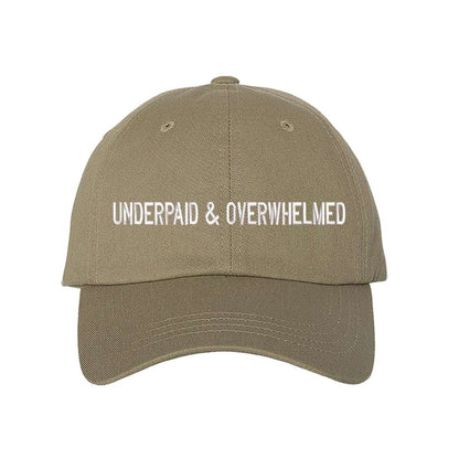 Khaki baseball hat with the phrase underpaid &amp; overwhelmed embroidered on it-DSY Lifestyle