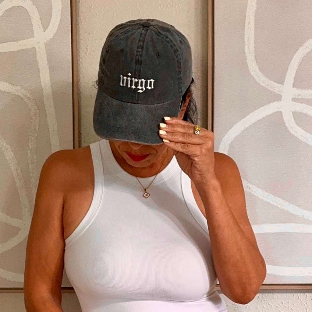 Female wearing a black washed baseball hat embroidered with Virgo 