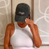 Female wearing a black washed baseball hat embroidered with Virgo 