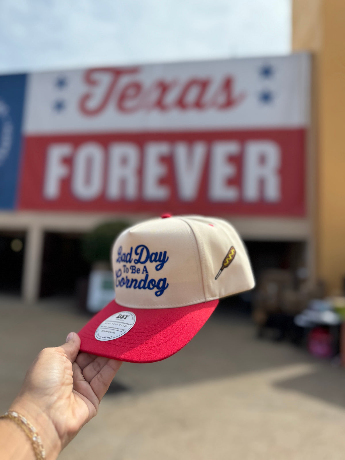 Side view of the Natural / Red Bill Bad Day To Be A Corndog hat showing the embroidered corndog on the side panel