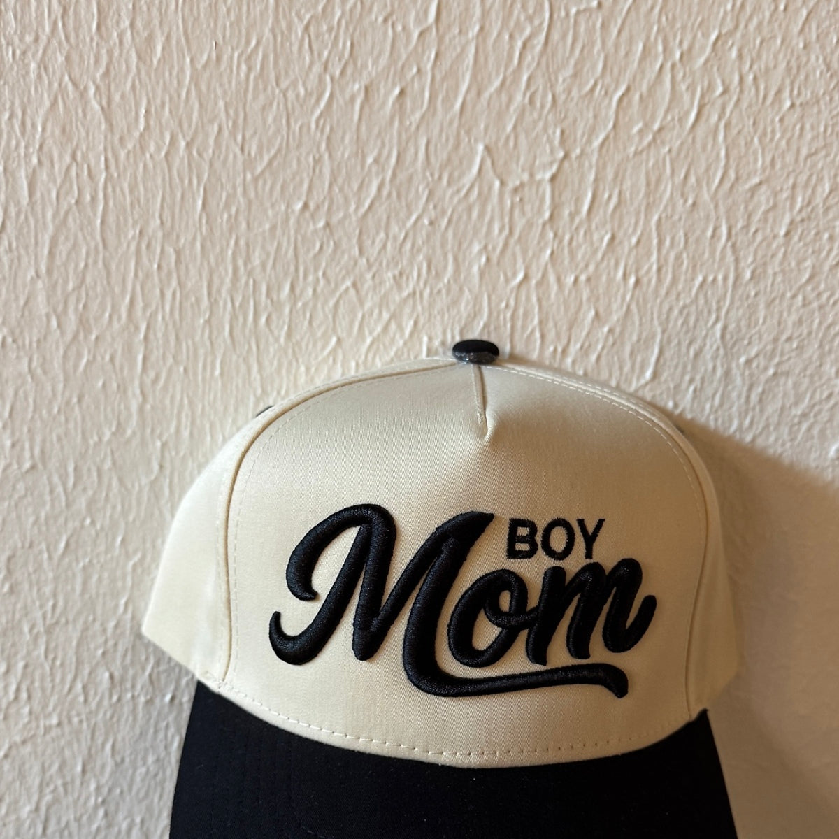 Close-up of Boy Mom machine embroidery on a two-tone trucker hat