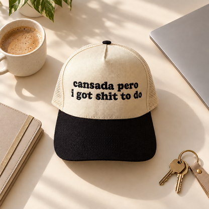 Cansada Pero I Got Shit To Do two-tone embroidered trucker hat styled flat lay