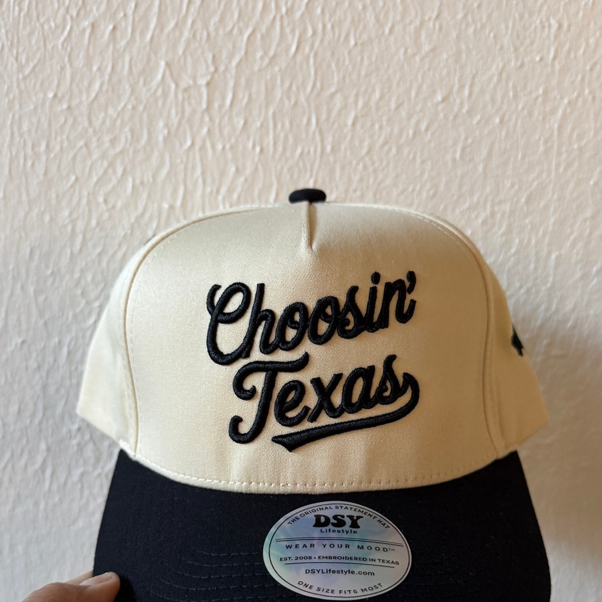 Close-up of Choosin’ Texas machine embroidery on a two-tone trucker hat