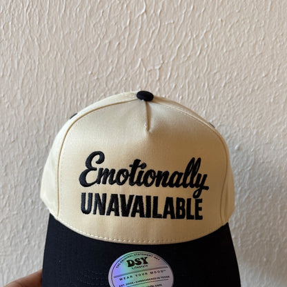 Close-up of Emotionally Unavailable machine embroidery on a two-tone trucker hat