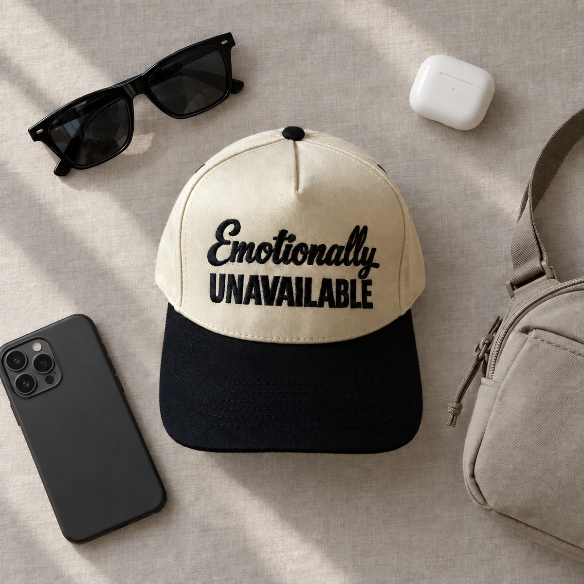 Emotionally Unavailable two-tone embroidered trucker hat styled flat lay