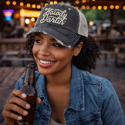 Female holding a bottle of beer wearing a Black DSY Lifestyle distressed trucker hat featuring the words Howdy Darlin in bold western-style embroidery. - DSY Lifestyle