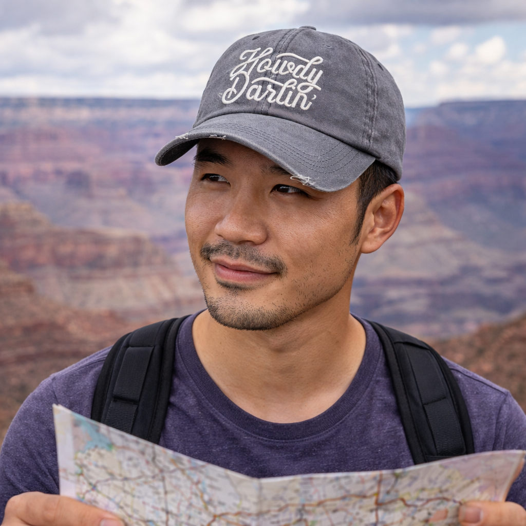 Male explorer with Grand Canyon backdrop wearing a Gray DSY Lifestyle washed cotton baseball hat with "Howdy Darlin’" embroidered on the front. - DSY Lifestyle