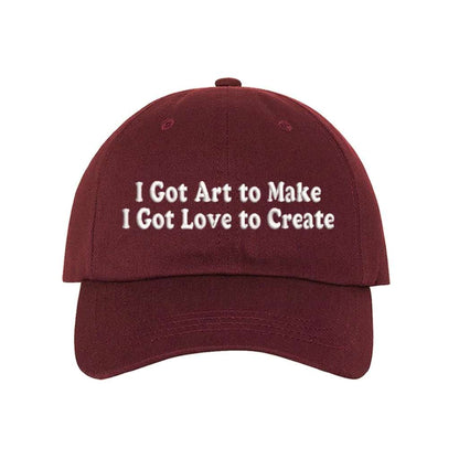Burgundy baseball hat embroidered with the phrase I Got Art to Make I Got Love to Create - DSY Lifestyle