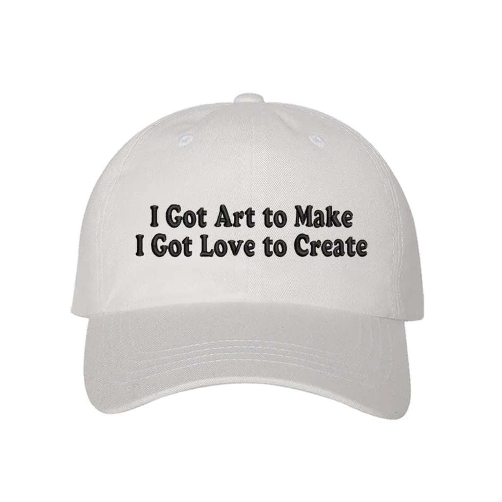 White baseball hat embroidered with the phrase I Got Art to Make I Got Love to Create - DSY Lifestyle