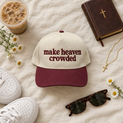 Make heaven crowded trucker hat styled flat lay with a Bible, cross necklace, iced coffee, sneakers, and daisies