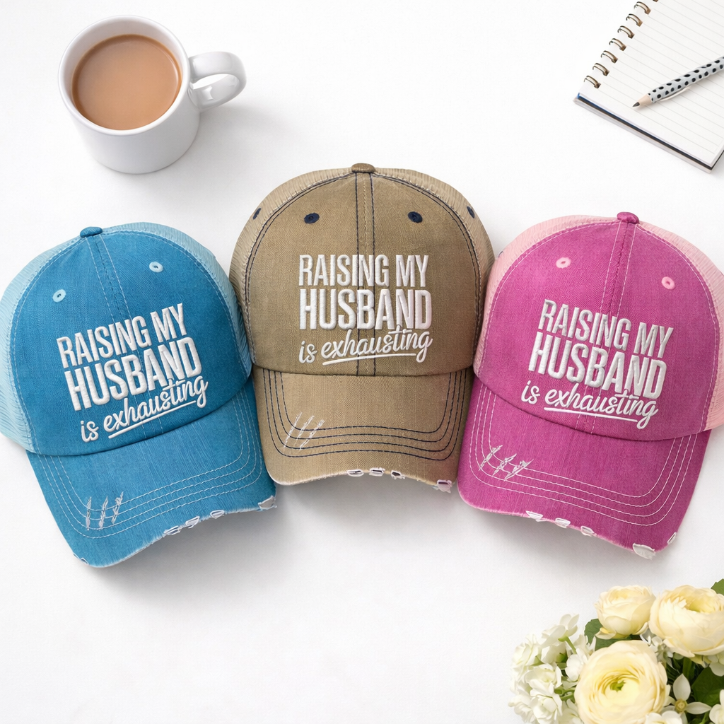 Flat lay of Aqua, Khaki, and Pink DSY Lifestyle distressed trucker hats featuring the phrase Raising My Husband Is Exhausting in bold, professional embroidery. - DSY Lifestyle