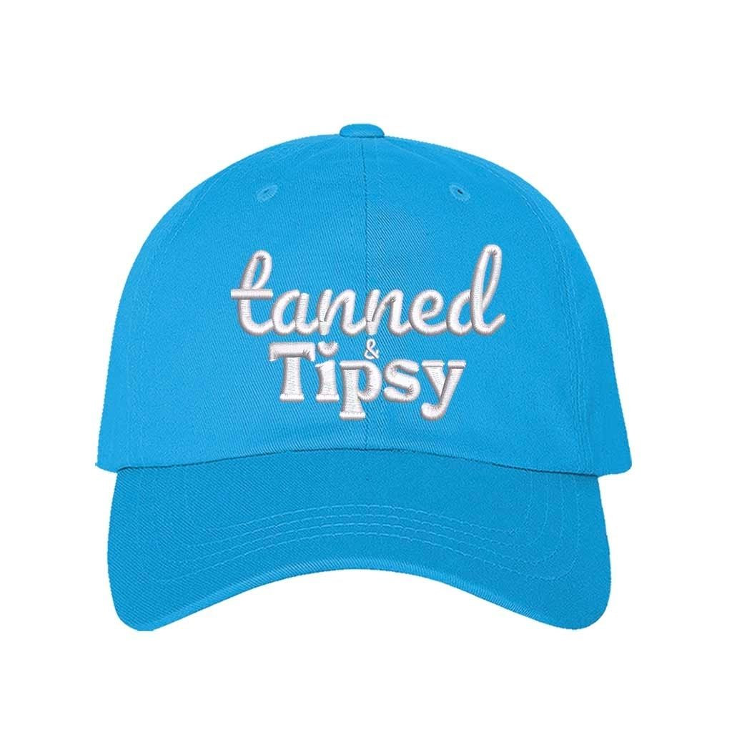 Aqua Tanned and Tipsy Embroidered Baseball Hat in classic cotton with pre-curved brim and hook and loop closure, perfect for beach days and summer drinks. DSY Lifestyle.