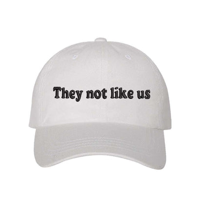 White baseball hat embroidered with the phrase They Not Like Us -DSY Lifestyle
