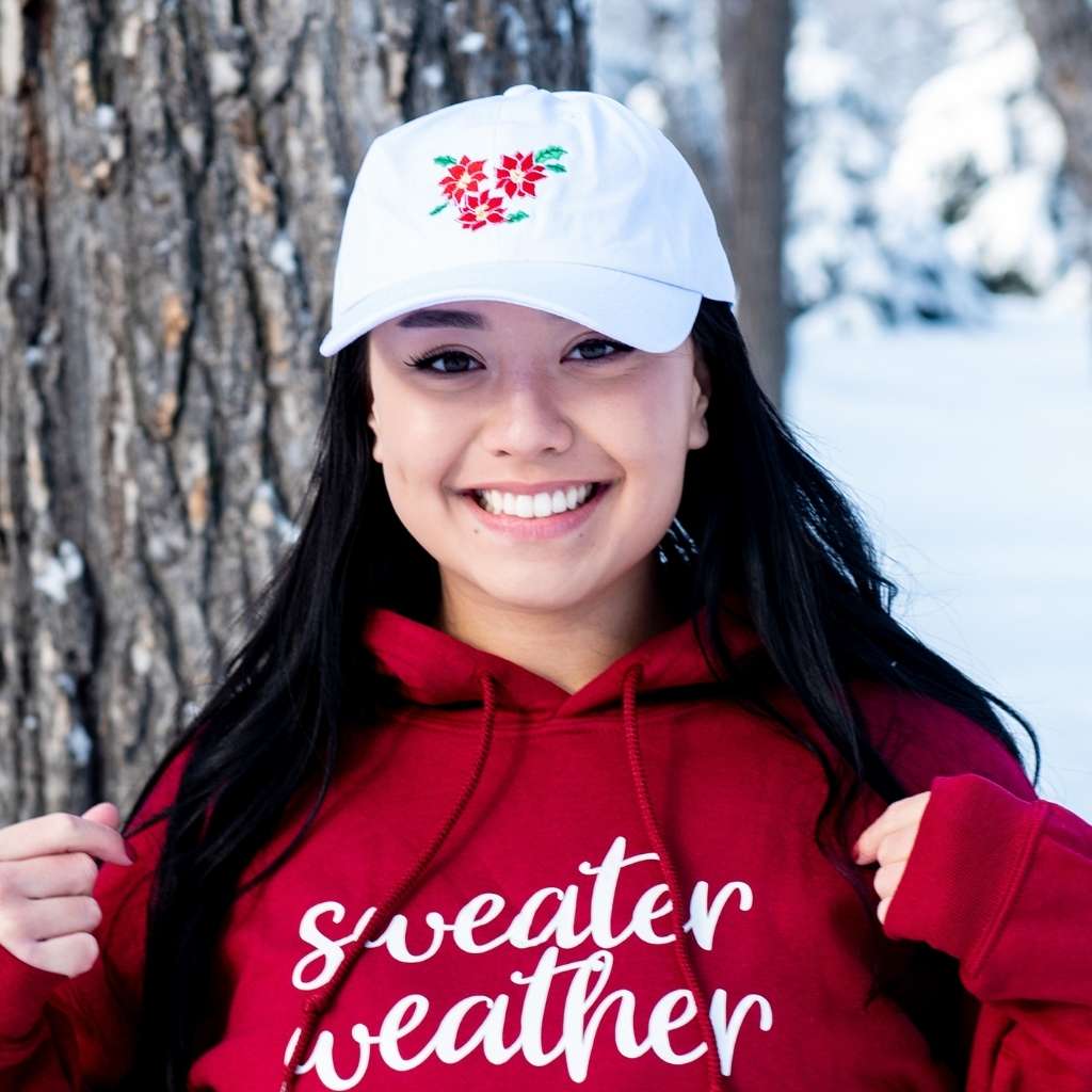 Female wearing a white baseball hat embroidered with poinsettias - DSY Lifestyle